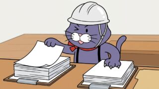 2種類の書類を見比べる猫のマスコット